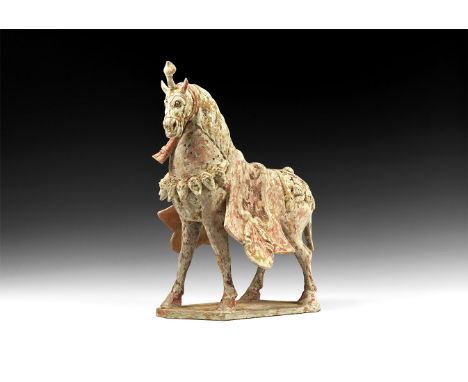 Warring States Period, 475-221 BC. A ceramic figure of a horse standing on an irregular base, with finely modelled harness, s