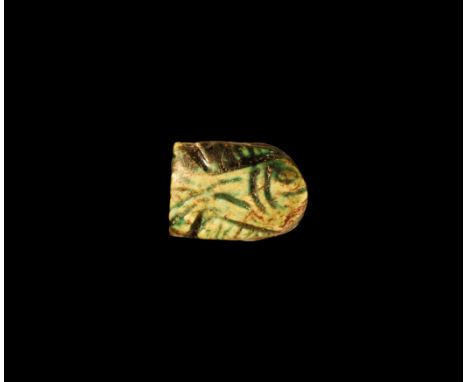 Late Period, 664-332 BC. A green glazed composition amuletic bead with reserved wedjat to one face, fish to the other. Cf. Fl