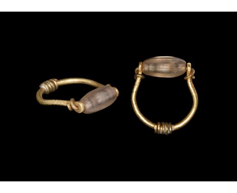 New Kingdom, 1550-1070 BC. A gold ring with round-section penannular hoop, ends forming an axle and coiled about the shank, s