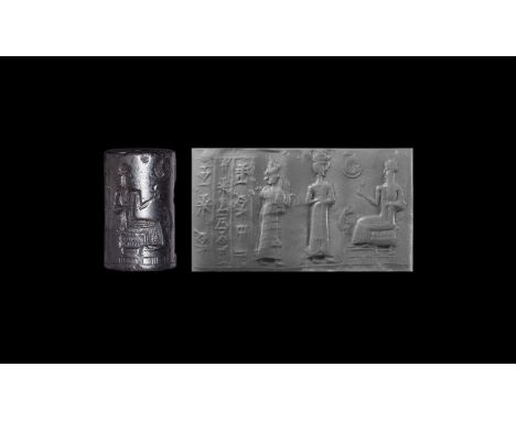 20th-18th century BC. A carved haematite cylinder seal with a male deity seated on a throne, left hand holding a cup, in the 