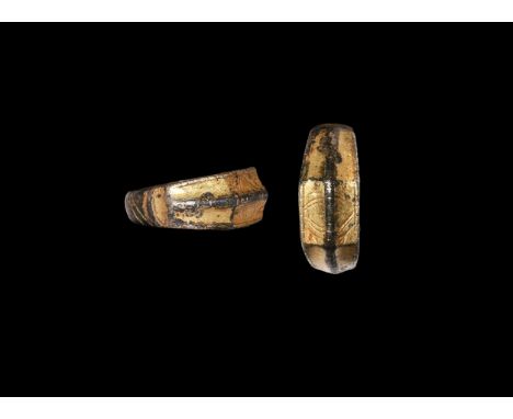 15th century AD. A silver-gilt finger ring with D-section underside and incised slash detailing, scooped shoulders and plaque