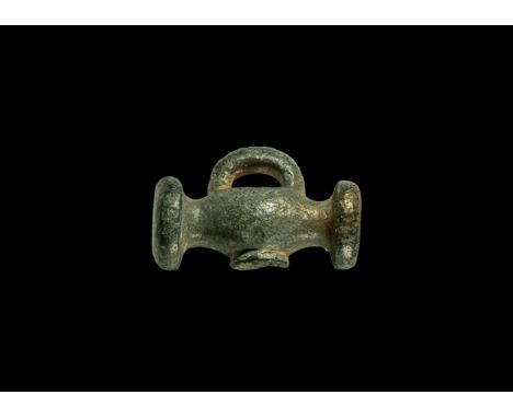 1st century BC-1st century AD. A bronze toggle fastener comprising a bulb with disc to each end, round recess to the undersid