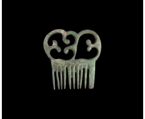 10th-12th century AD. A bronze openwork comb with strong teeth and scroll decoration.  16.51 grams, 44mm (1 3/4"). Property o