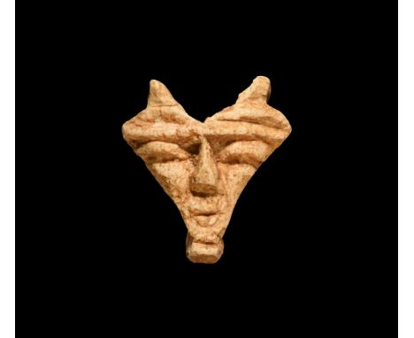 New Kingdom, 1550-1070 BC. A white glazed composition triangular mask with short beard, twin loops above the eyes. Cf. Andrew