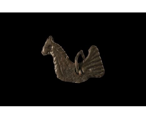 10th-12th century AD. A flat bronze pendant of a bird with wide ribbed tail and decorated body, possibly a cockerel; pierced 