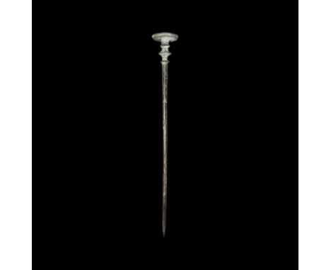 2nd millennium BC. A bronze tapering dress pin with hatched detail to the upper shank, three flange collars with beaded edges