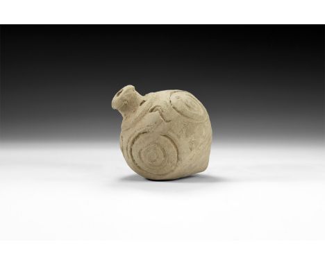 9th-11th century AD. A hollow-formed piriform ceramic vessel with low rim to the mouth, piriform body with spiral and geometr