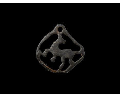 12th century AD. A bronze openwork pendant comprising an advancing regardant stag(?) in a lozengiform frame with pierced lug 