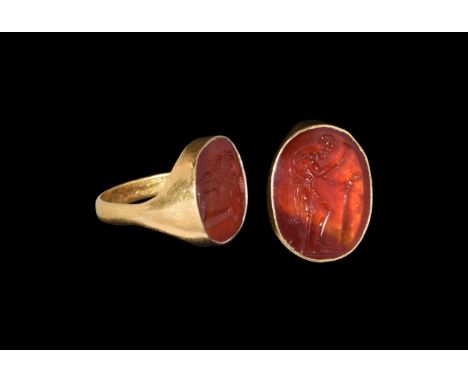 2nd-3rd century AD. A flat-section gold hoop with large discoid bezel, inset carnelian cloison with intaglio image of a stand