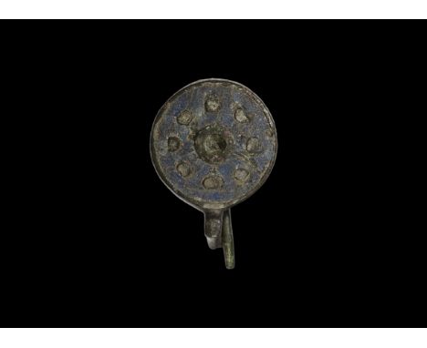 2nd century AD. A bronze enamelled disc brooch with reserved pellets and central roundel, sprung pin and catch to the reverse