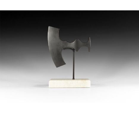 10th-12th century AD. A hand-forged iron axehead with T-shaped blade and curved edge, scalloped profile to the shank, lateral