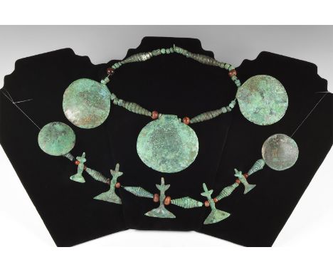 1st millennium BC. A group of two strings with beads and pendants comprising of: five large bronze discs, slightly domed; fiv