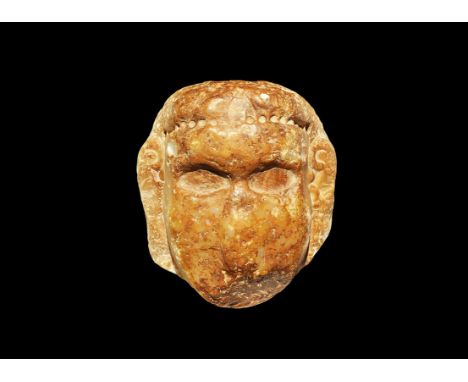 3rd-2nd century BC. A carved alabaster block with face and hair detail, oversized lentoid eye sockets to accept marble insert