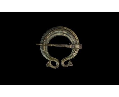 3rd-4th century AD. A tiered lozenge-section penannular brooch with returned trumpet terminals, round-section spike pin. Cf. 