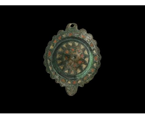 2nd century AD. A bronze disc brooch with dentilled rim, central boss with enamelled cells, lug below and pierced lug above, 