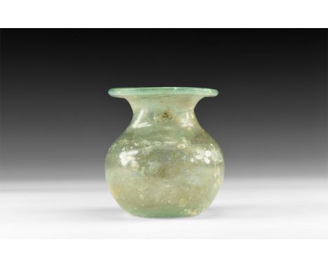 4th-5th century AD. An iridescent glass jar with dimple base, bulbous body, broad flared mouth with rolled rim. Cf. Whitehous