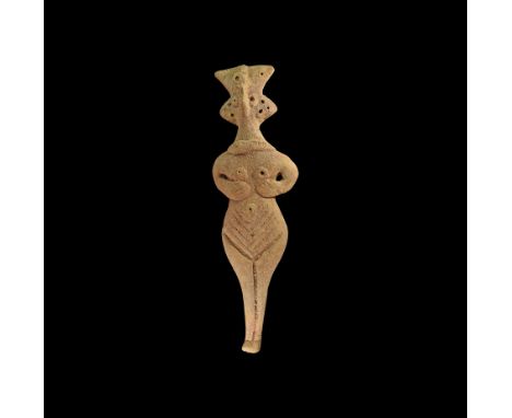 12th-7th century BC. A ceramic female figure with elaborate headdress, pinched facial features, applied necklace band, arms b