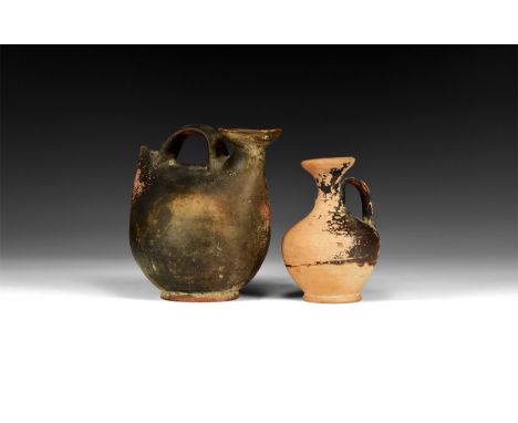 5th-3rd century BC. A mixed ceramic group comprising: a flask with trumpet mouth and strap handle to the shoulder; a flask wi