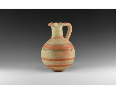 Iron Age, 12th-9th century BC. A bulbous ceramic vessel with basal ring, tubular neck with pinched trefoil rim, strap handle,