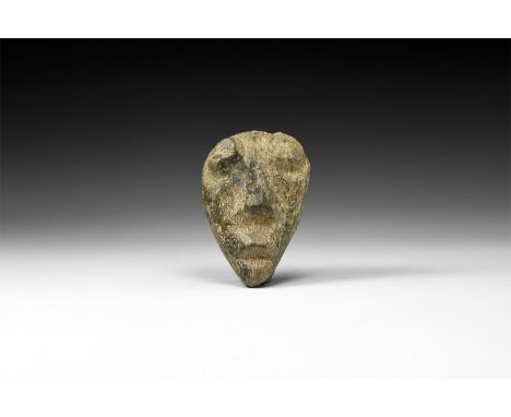 Pliocene Period, 5.2-2.5 million years BP. A Mastodon fossil bone carving of a human face; from Island of Java.  72 grams, 67