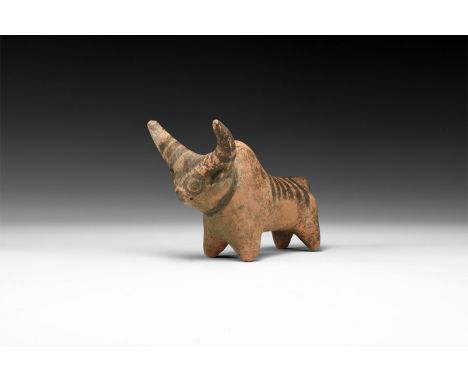 2nd millennium BC. A ceramic figurine of a zebu with exaggerated crescent horns, painted stripes to the horns and rump, trian