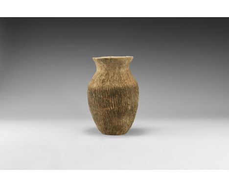 3rd millennium BC. A biconvex ceramic jar with flared rim, ridged leather texture to the body and shoulder.  789 grams, 18cm 