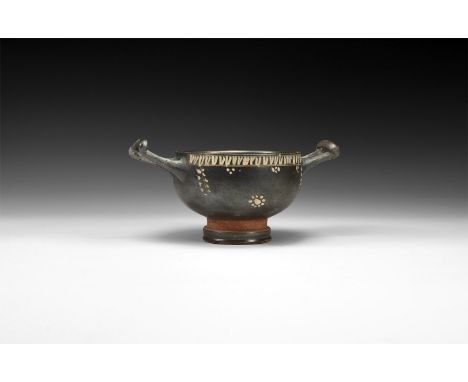 4th century BC. A ceramic kylix with tiered base, broad body, two round-section handles with transverse bar; band of white ov
