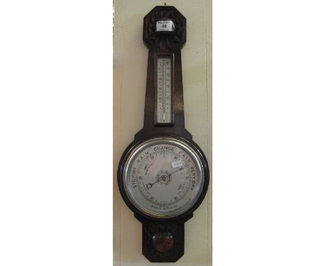 Mid Century oak aneroid wheel barometer with thermometer, having flower head moulded decoration.  64cm high.(B.P. 24% incl. V
