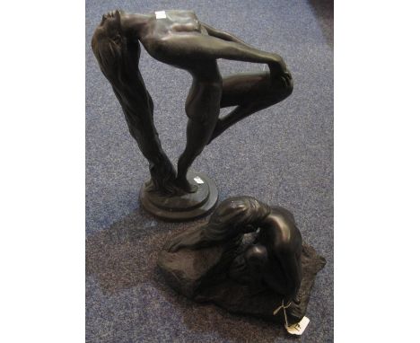 Two modern black ceramic sculptures of nude female figures, one with particularly long hair, in a stretching pose, the other 