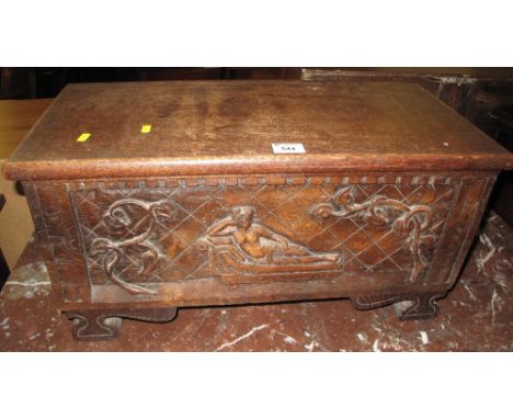 Small oak box of rectangular form with hinged lid, the front panel with a carved nude lady on a chaise lounge amongst foliage