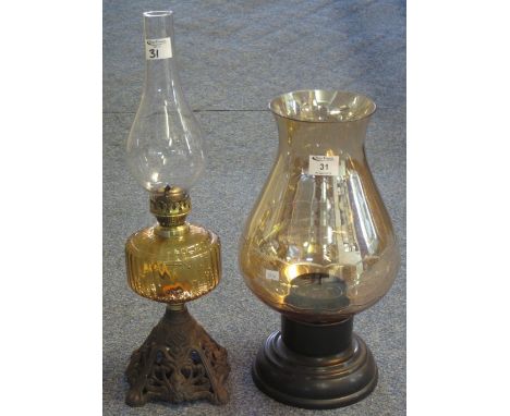 Single burner brass oil lamp with coloured glass reservoir and pierced cast metal base, with clear chimney, together with a m