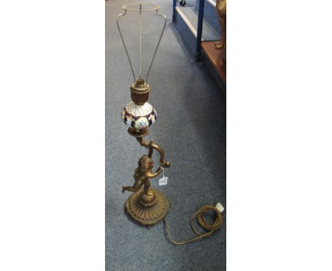 Heavy brass table lamp with ceramic, gilded and florally painted base, supported by a brass cherub on a circular, fluted supp