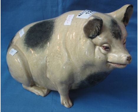 Staffordshire pottery study of a seated pig.(B.P. 24% incl. VAT)    CONDITION REPORT:  Chip to front right trotter.  Signific