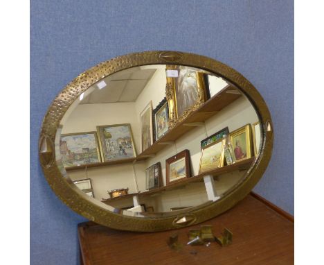 An Arts and Crafts oval brass framed mirror 