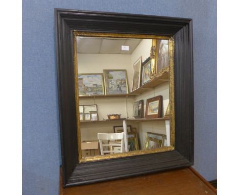 An ebonised and parcel gilt framed mirror 