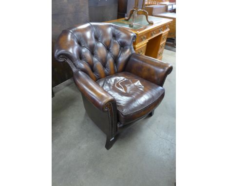 A Wade Upholstery mahogany and chestnut brown leather upholstered armchair 