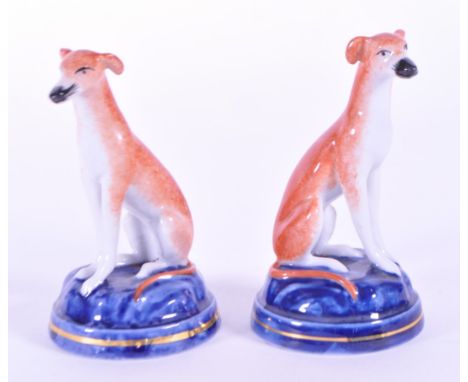 Two 19th century ceramic Staffordshire dogs. Featuring a whippet / greyhound in a burnt sienna glaze sat upon a round plinth 