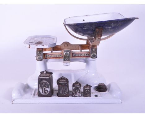 Harrods Ltd - Early 20th century London cast iron weighing scales painted in a white enamel. Featured with a moulded base and