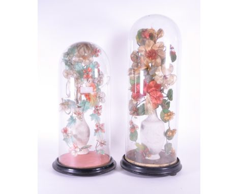 Two late 19th century French globe de mariée wedding glass domes containing bisque porcelain vases with wire and straw flower