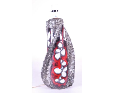 A mid 20th Century Italian San Marino decorated lamp base with a stylised study of white flowers against a red glazed ground 