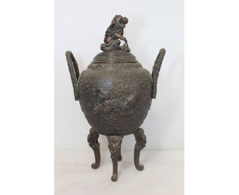 Chinese Qing dynasty patinated bronze censer vase of twin handled ovoid form on four dragon mask scroll supports and domed co