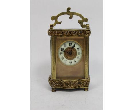 Late 19th century miniature carriage clock with sunken enamel dial. Gilded foliate borders with glass exhibition panels. Work