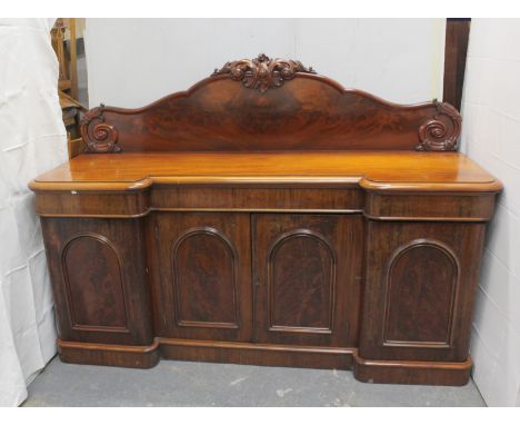 Victorian mahogany inverted breakfront sideboard the carved back over four arched panelled door cupboards, on plinth base, 21