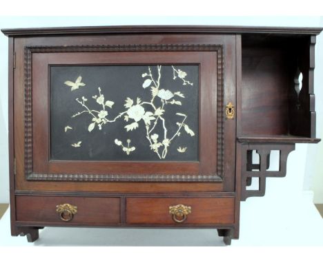 Aesthetic mahogany wall cabinet in the manner of Godwin, the single door inset with Shibayama panel depicting a bird amongst 