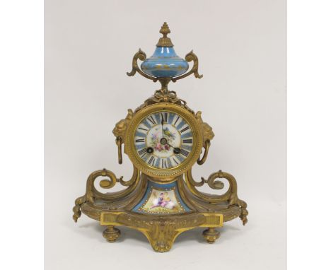 French Ormulu mantel clock with sevres style porcelain dial, a similar panel and vase finial and flanking scrolls on oval bas