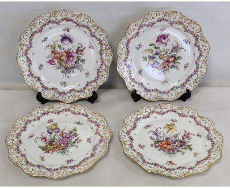 Set of four Dresden porcelain plates with polychrome floral decoration and gilt foliate scrolls to lobed rims, painted blue m