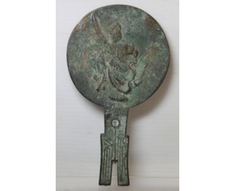 Antique Chinese bronze hand mirror of achaic form, the circular panel decorated with a deity and deer on shaped pronged handl