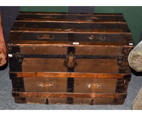 An early 20th century wood and metal bound American steamer trunk, 87cm by 53cm by 57cm