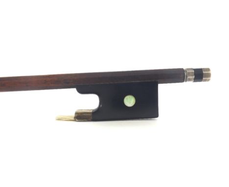 German silver mounted violin bow stamped Nurnberger, the stick round, the ebony frog inlaid with pearl eyes and the ebony adj