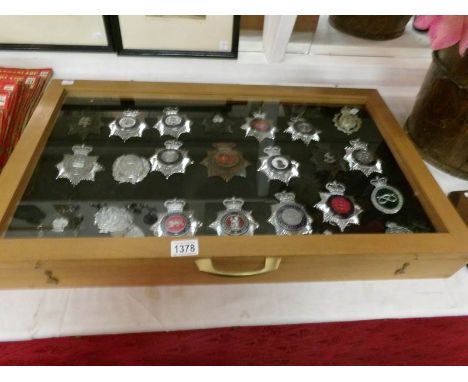 A display case containing 23 Police helmet badges including Nottinghamshire, Ministry of Defence, Royal Gibraltar, British Tr